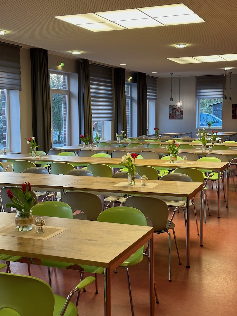 Essenssaal in der Jugendherberge Jever mit Frühlingsdeko in Form von kleinen Tulpensträußen auf den Tischen
